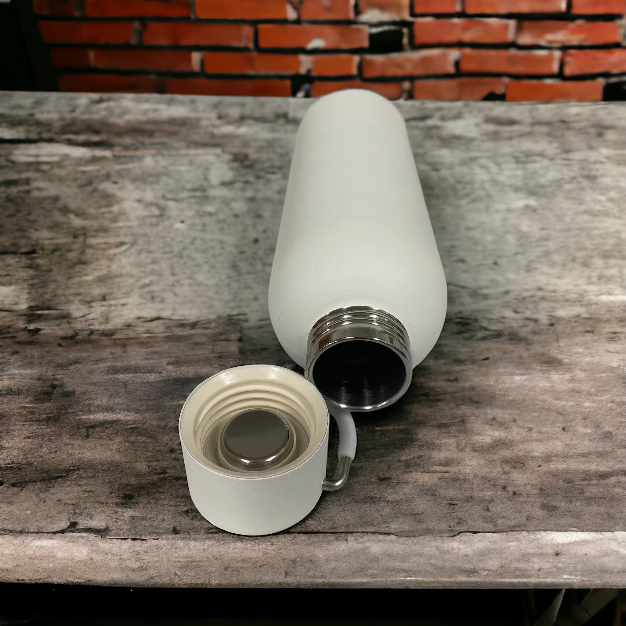 Multiple custom thermos flasks in various colors with corporate logos on modern office desk