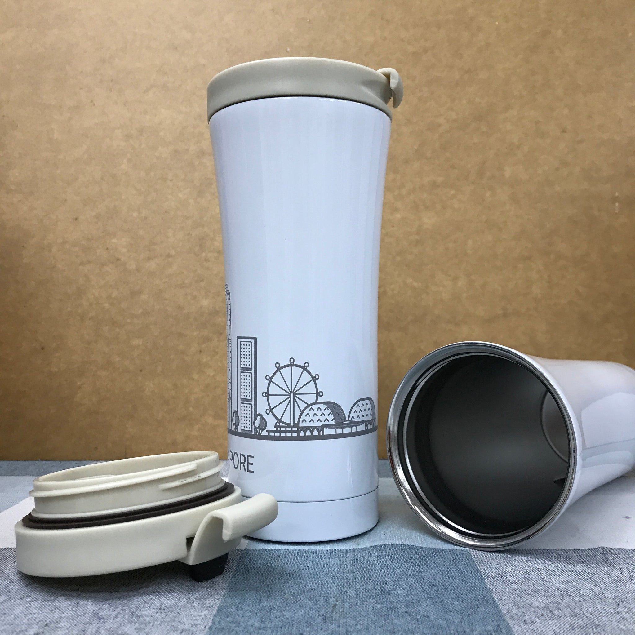 Custom thermos flask with lid open showing wide mouth opening on office desk with laptop