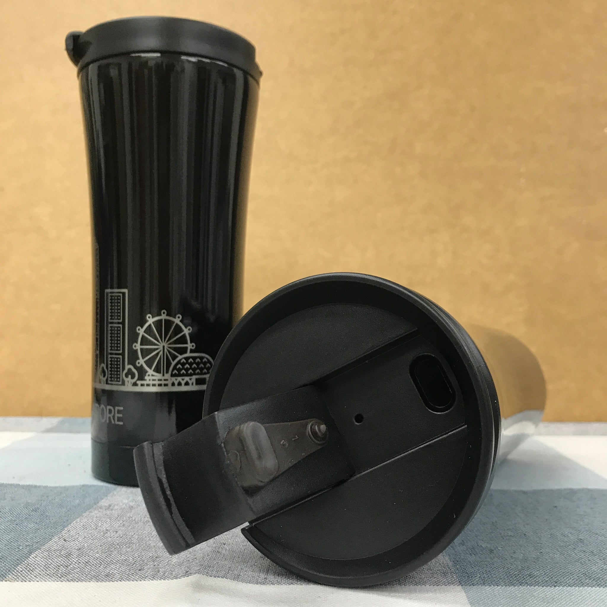 Multiple custom thermos flasks in various colors with corporate logos on conference table with Singapore skyline