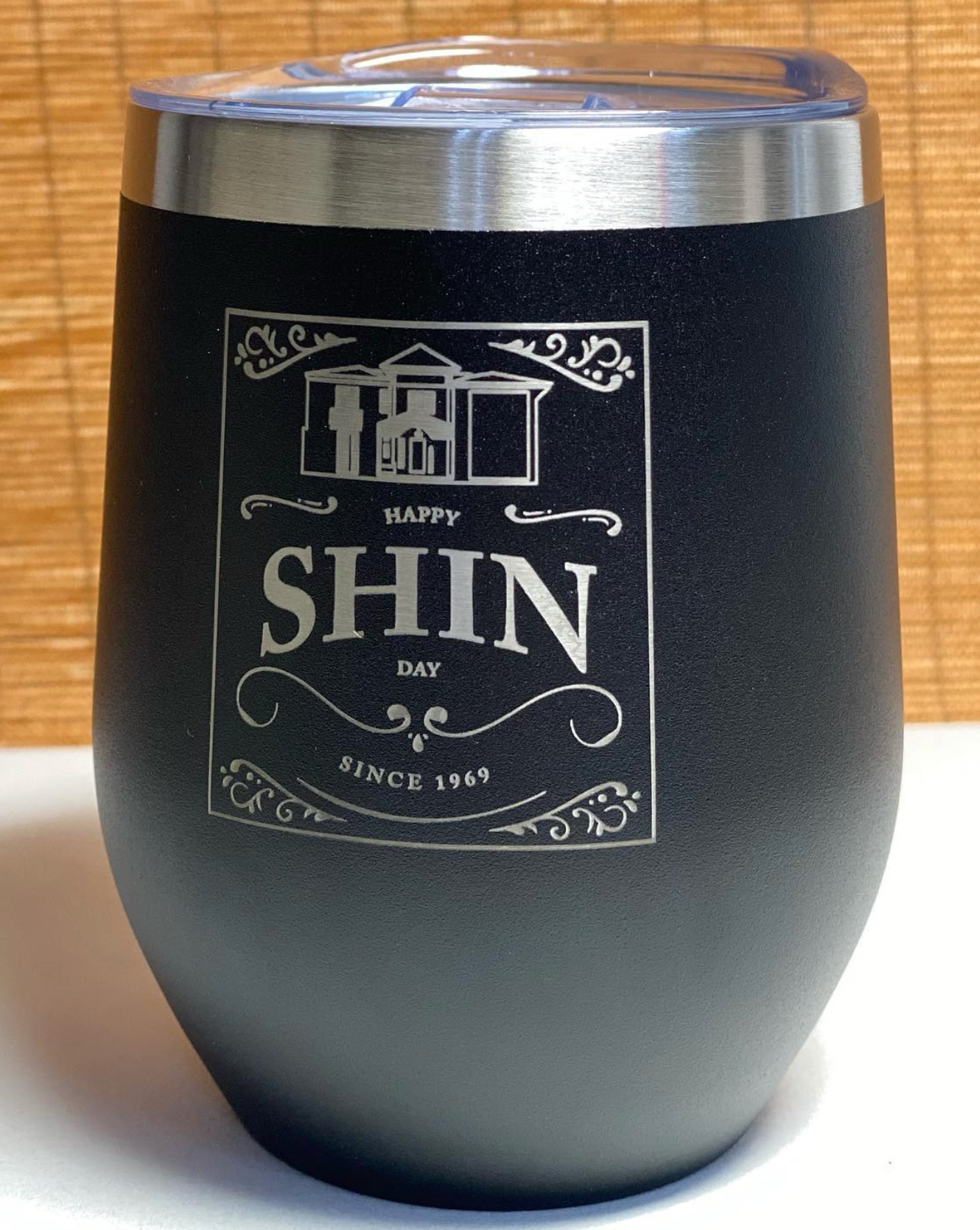 Custom tumbler with flip lid open showing drinking spout on office desk with laptop and coffee