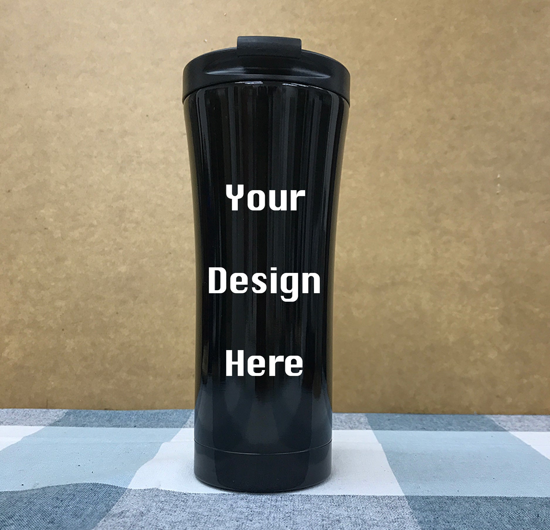 Custom tumbler with slide lid open showing drinking opening on cafe table with coffee