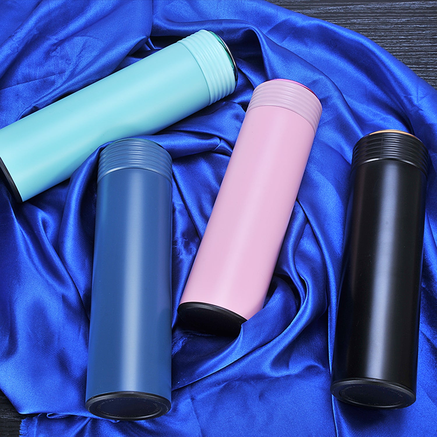 Custom thermos flask with push button lid open showing drinking spout on office desk with laptop